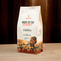 Coffee bag with 'Back to the Essence' branding on a wooden surface